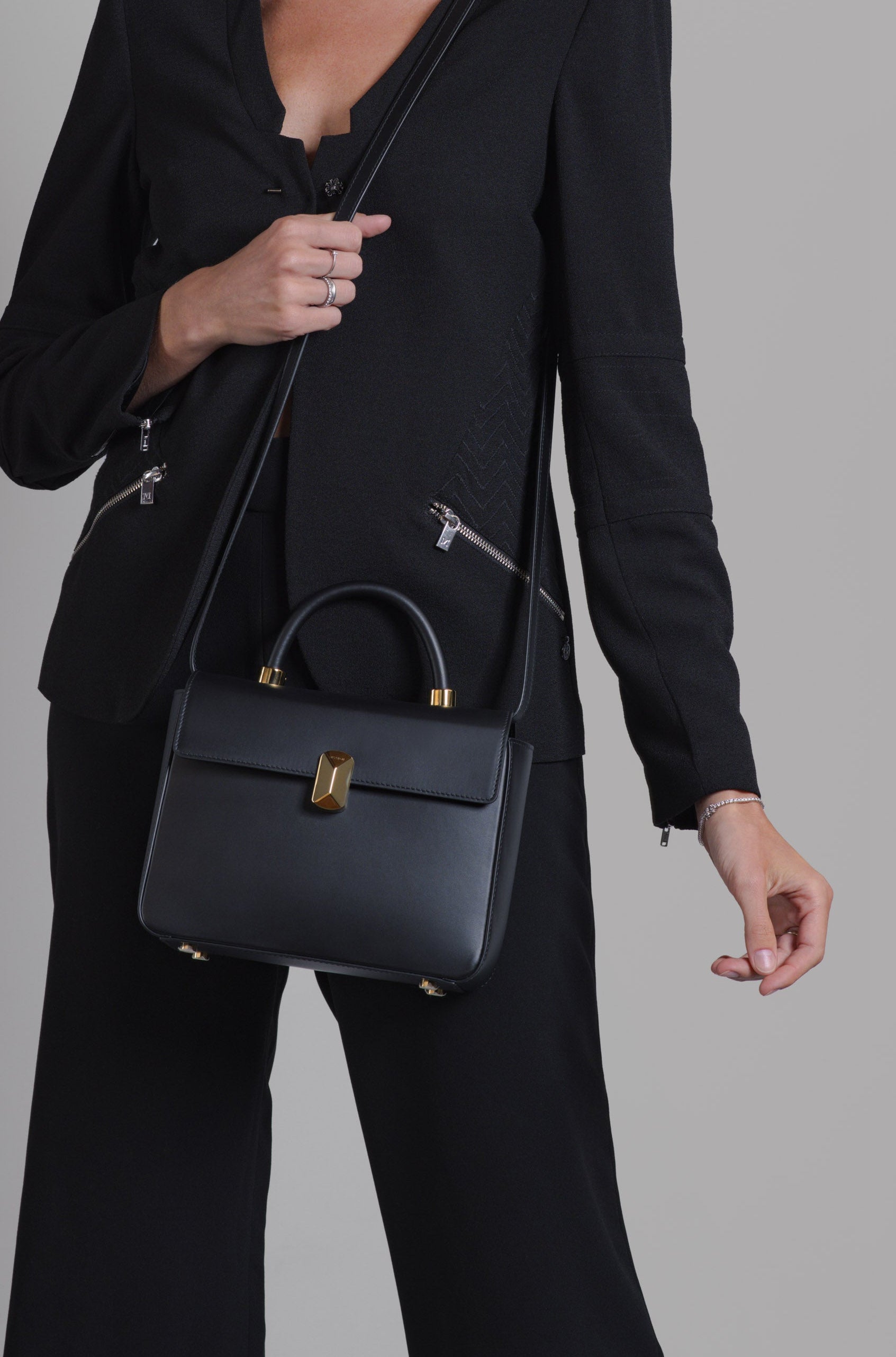 Woman holding No. 16 Italian leather top handle bag
